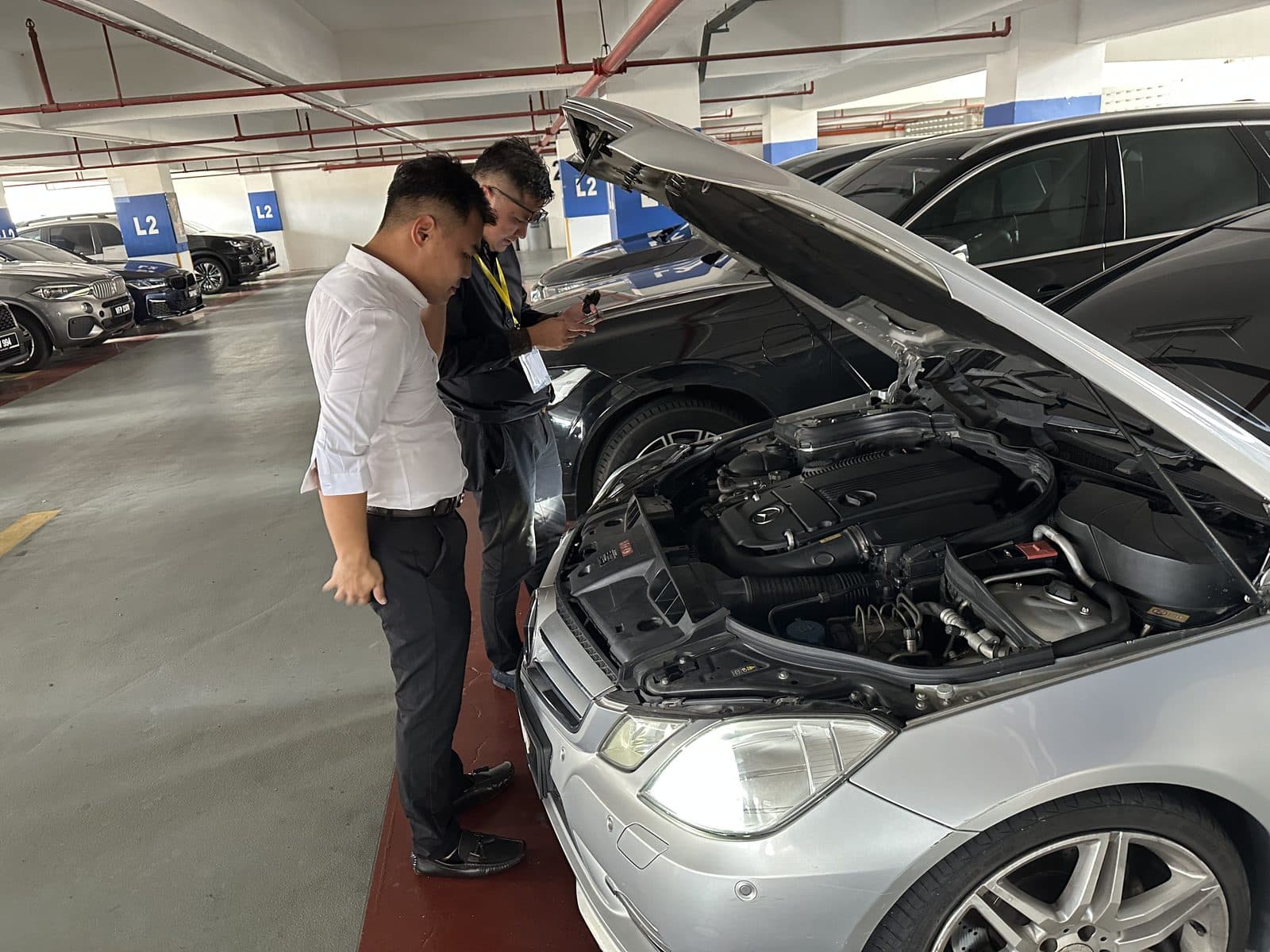 CarShifu technician inspecting an open engine bay during a roadside breakdown diagnosis in KL
