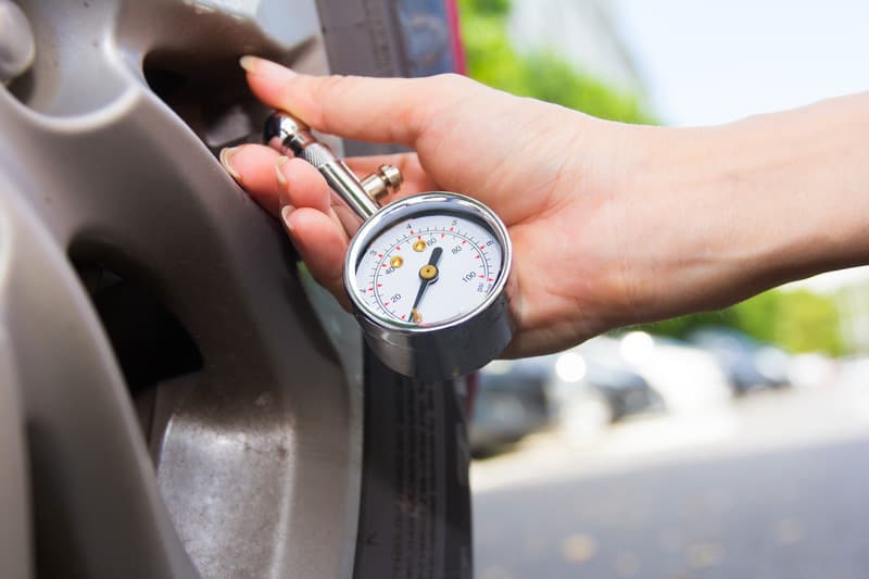 Checking tyre pressure with a gauge on-site